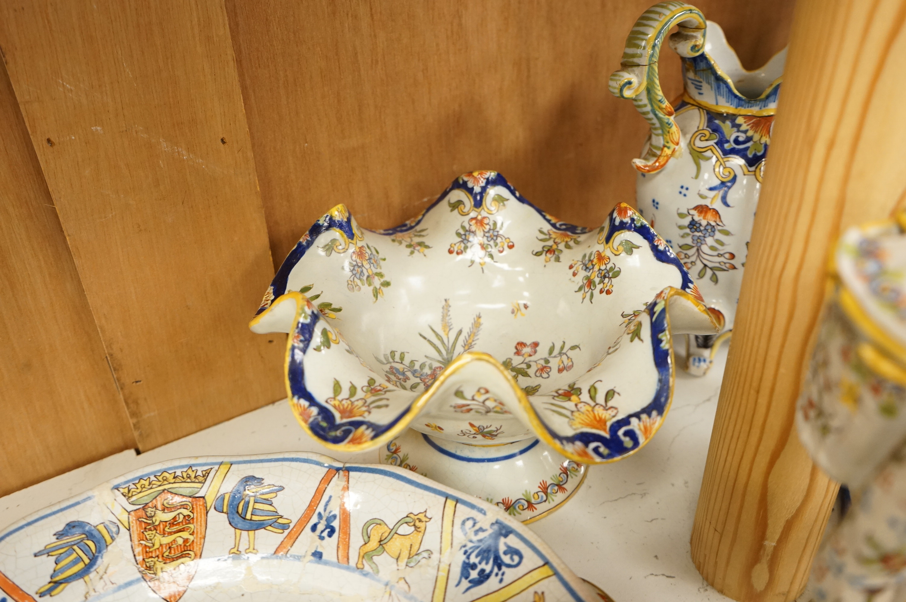 A collection of early 20th century French faience pieces to include a pair of salts in the form of pigs and candlesticks, largest 27cm high